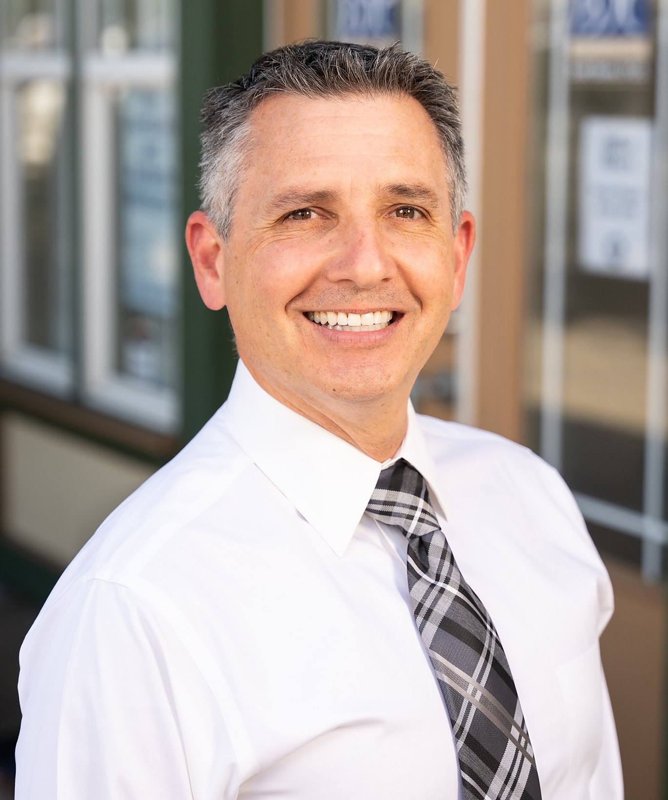 Dr. Scott Bonin, dentist at Bonin Dental Care, in a white dress shirt and tie outside his Windsor, CA office